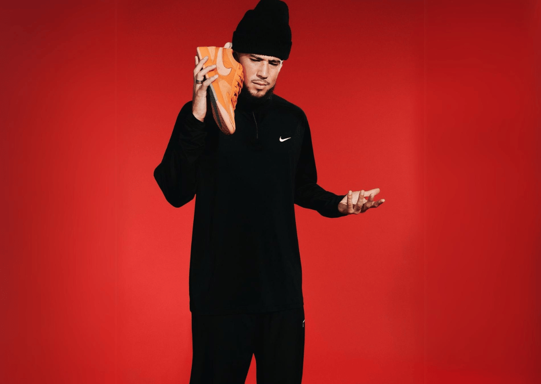 Devin Booker Posing With The Nike Book 1 Clay Orange