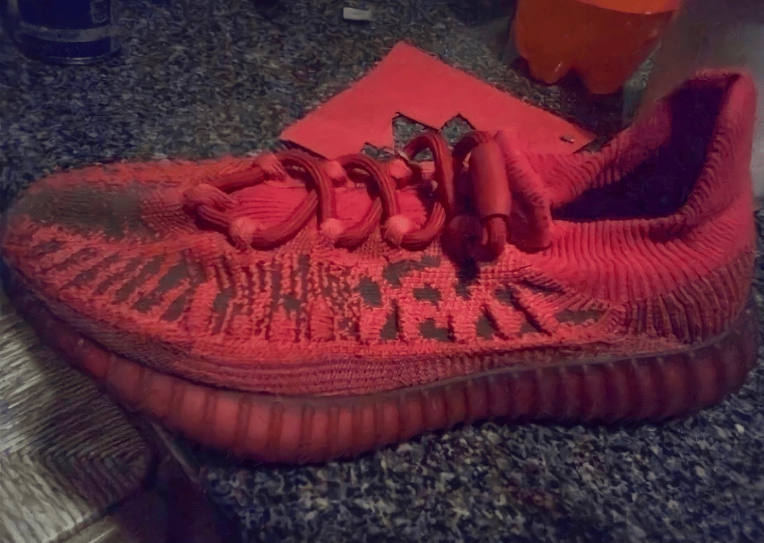 In hand image of the adidas Yeezy 350 V2 CMPCT Slate Red