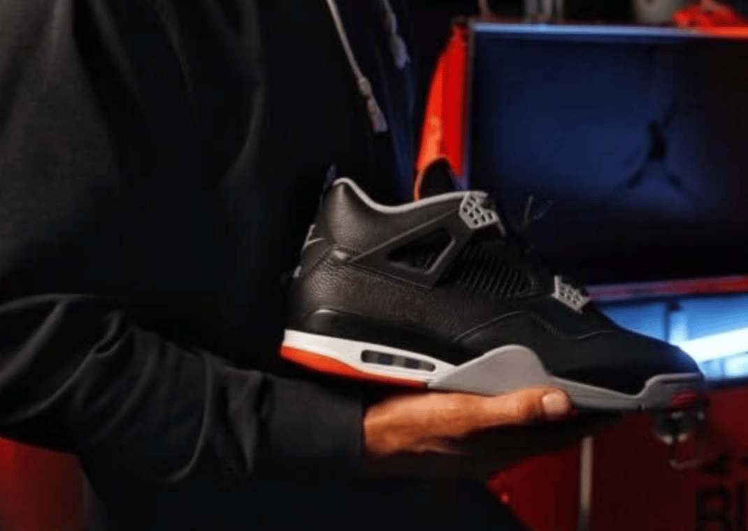 Roman Reigns Holding Jordan 4 Bred Reimagined