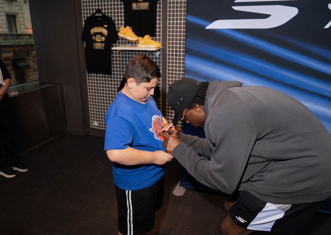 OG Anunoby signing an autograph for a young Knicks fan