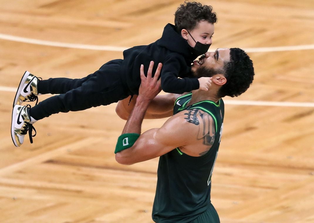 Jayson Tatum lifting up his son