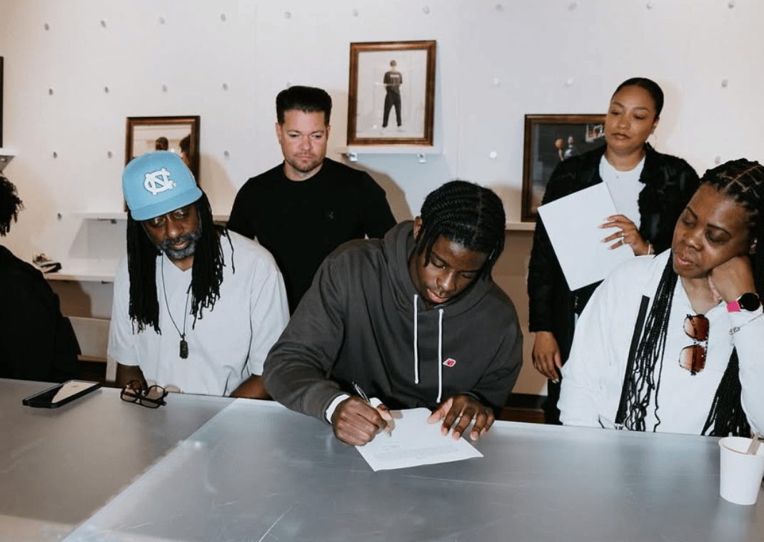 Caleb Wilson signing his deal with New Balance